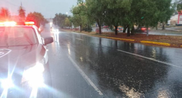 Unidad de Protección Civil y patrulla en calle inundada